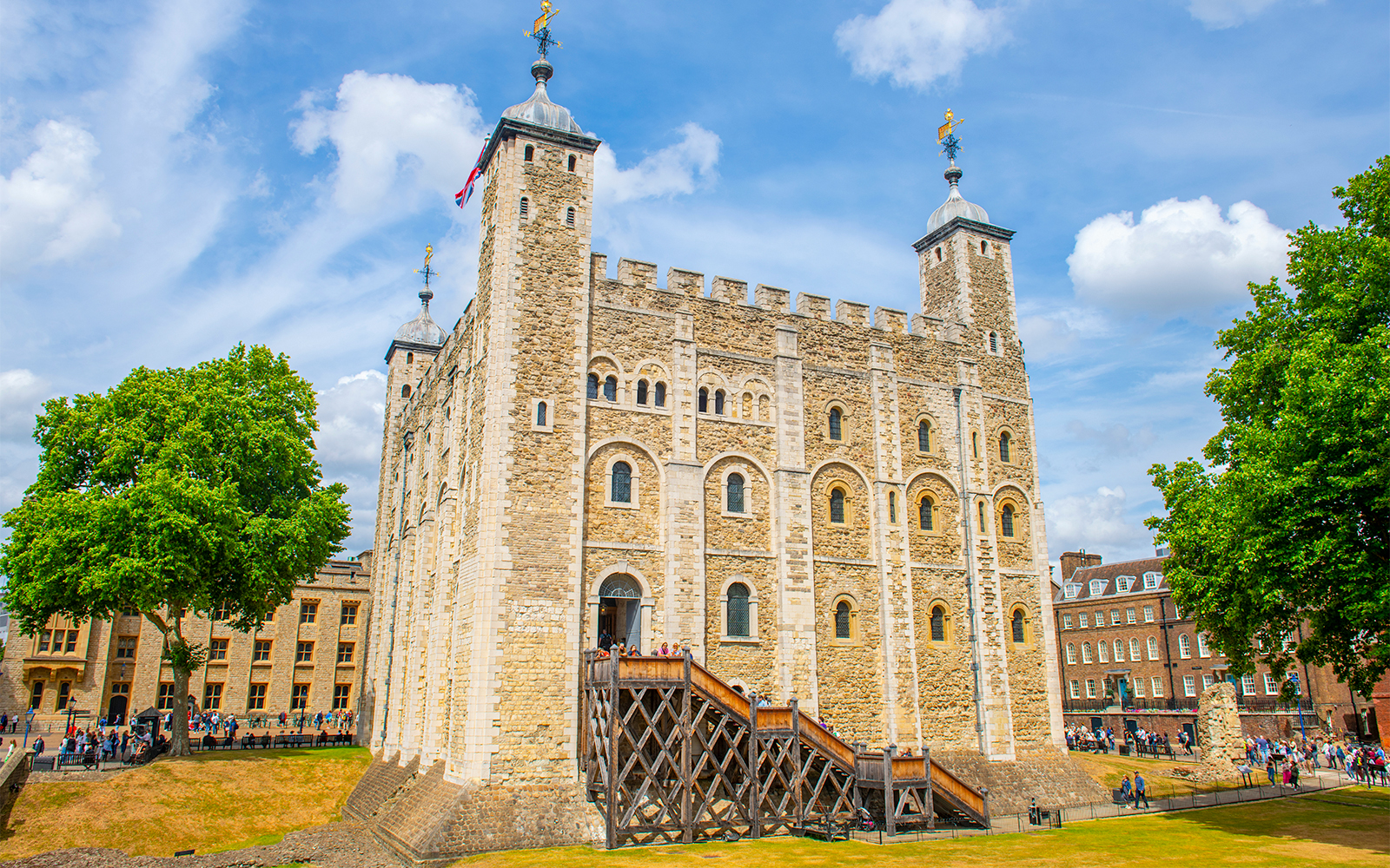 White Tower at the Tower of London with tourists exploring the historic site.
